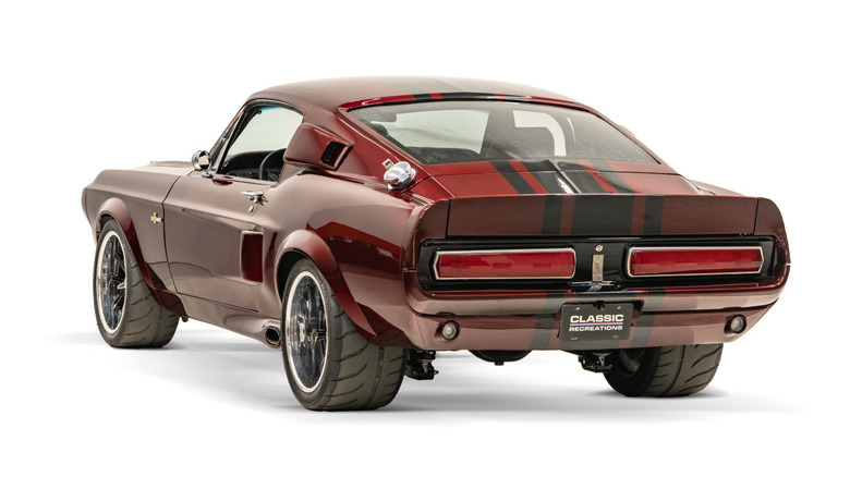 Красный рестомод Shelby GT500 1967 года выпуска, припаркованный в студии, вид сзади в три четверти.