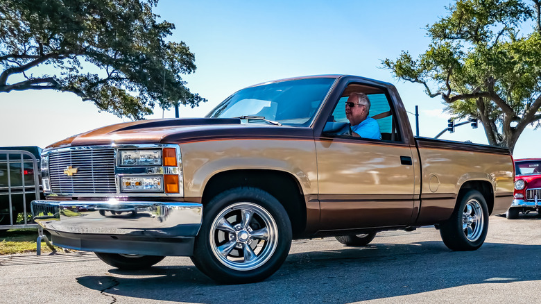 Вид спереди на 3/4 золотого пикапа Chevy Silverado OBS на автосалоне.