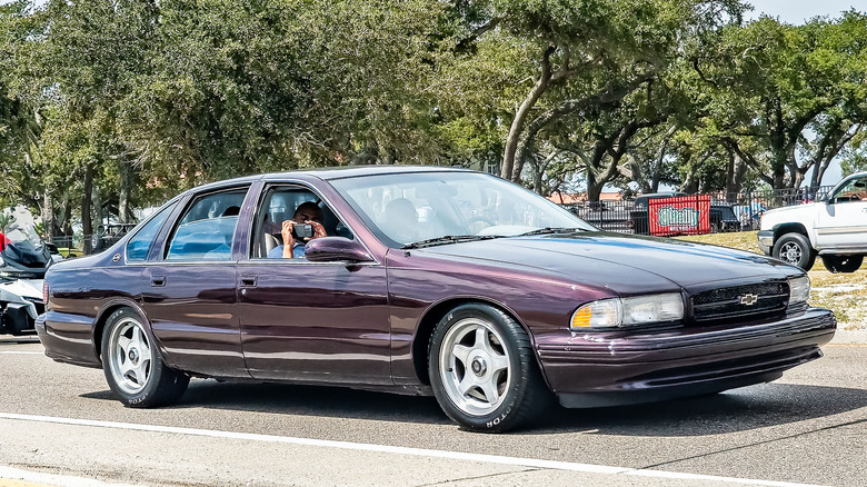 Вид спереди на 3/4 фиолетового Chevy Impala 1996 года выпуска на автосалоне.
