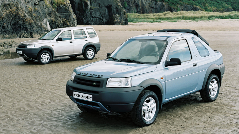 Пара Land Rover Freelander на пляже, один кабриолет и один пятидверный автомобиль.
