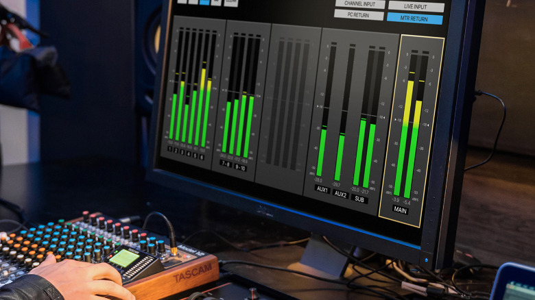 Человек, использующий микшер Tascam Model 12 с сопутствующим приложением на ПК.