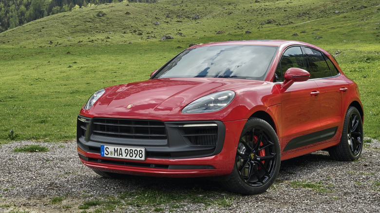 Вид спереди на 3/4 красного Porsche Macan GTS, припаркованного в горах.