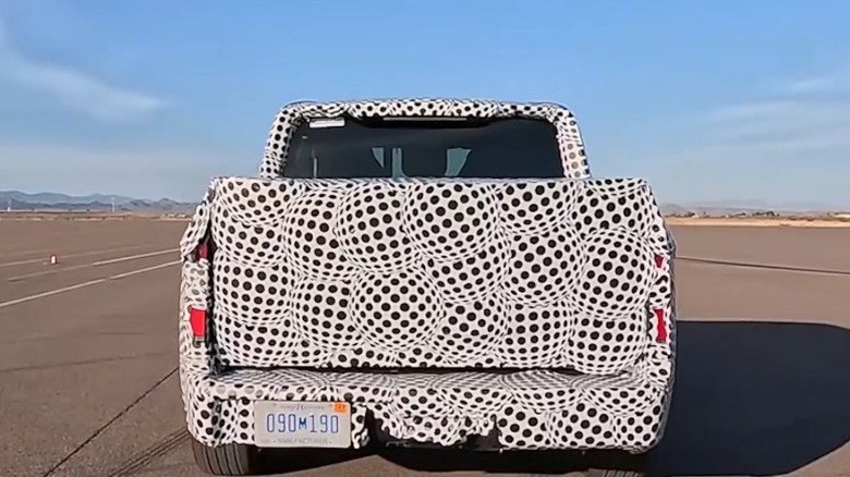 Вид сзади на прототип электромобиля Ford с камуфляжным рисунком