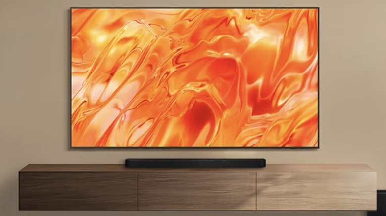 Телевизор Samsung, установленный на коричневой стене над современным развлекательным центром