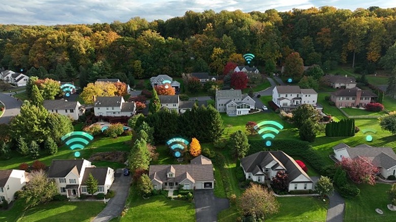 Вид с воздуха на загородные дома с символами Wi-Fi, наложенными над многими домами.