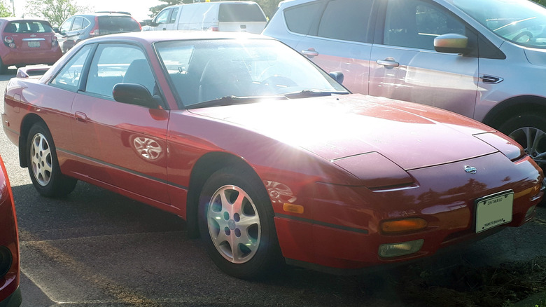 Купе Nissan S13 240SX припарковано на парковке, вид спереди справа в 3/4