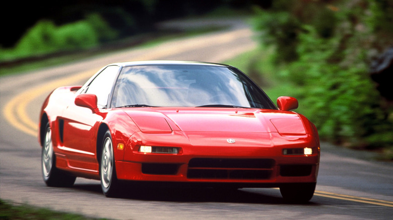 Acura NSX 1993 года движется на высокой скорости по национальной дороге, вид спереди справа в 3/4