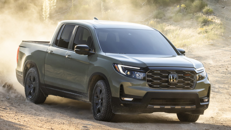 Вид спереди в 3/4: Honda Ridgeline поднимает пыль на бездорожье