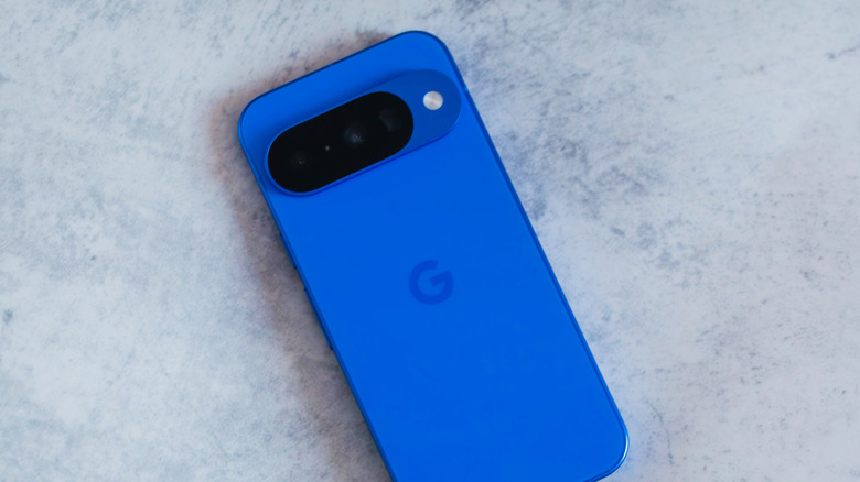Синий смартфон Pixel 10 лицевой стороной вниз на мраморе