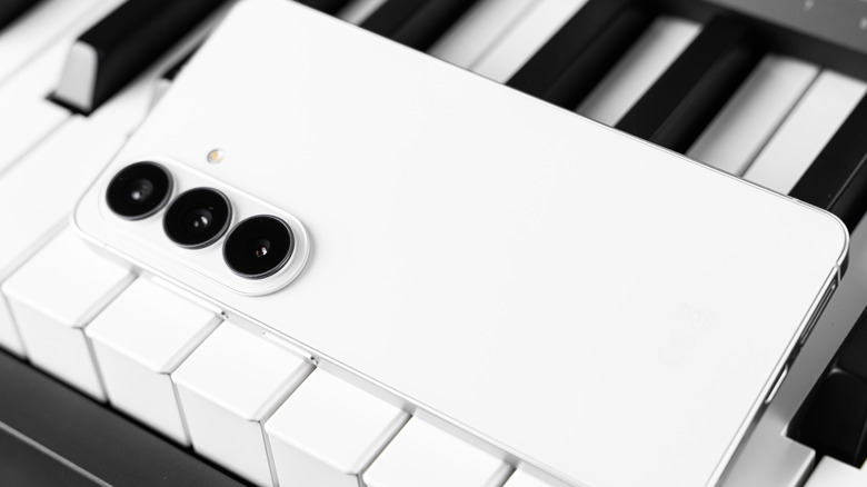 Белый Samsung Galaxy S26 на клавишах пианино