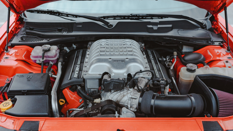 Крупный план оранжевого моторного отсека Hellcat HEMI V8 объемом 6,2 литра.