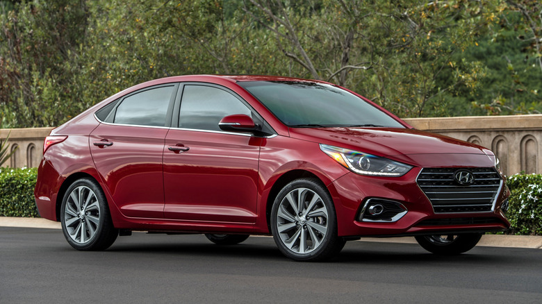 Вид спереди на 3/4 припаркованного красного Hyundai Accent 2022 года выпуска.