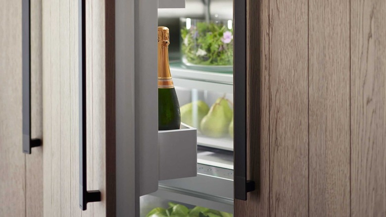 Крупный план бутылки шампанского в холодильнике Fisher & Paykel.