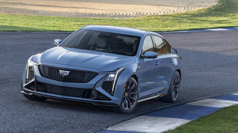 Вид спереди серого Cadillac CT5-V Blackwing 2026 года выпуска, припаркованного на гоночной трассе.