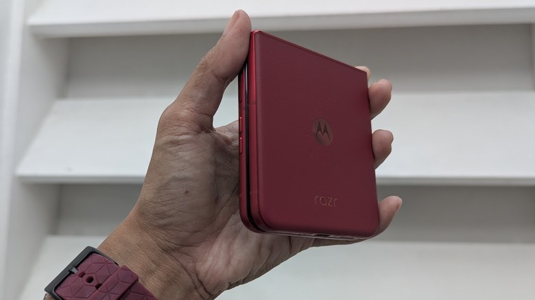 Рука держит сложенный Motorola Razr Ultra 2025 у белой стены
