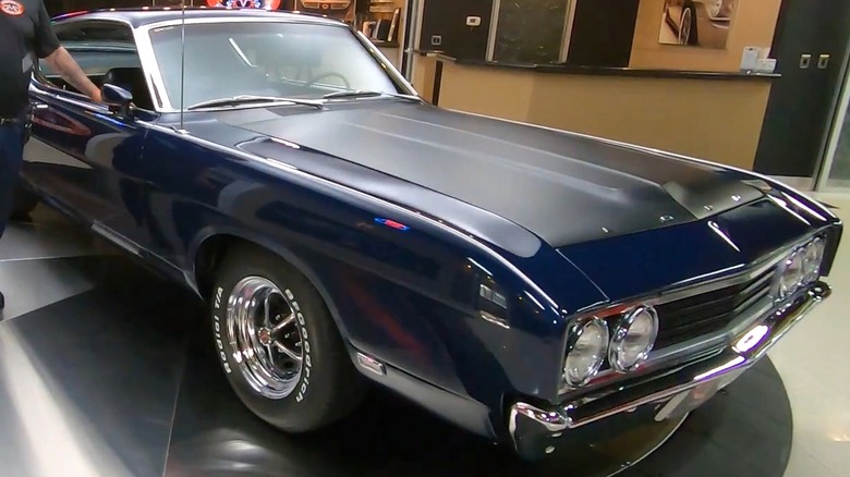 Темно-синий Ford Torino Talladega 1969 года выпуска на проигрывателе в автосалоне.