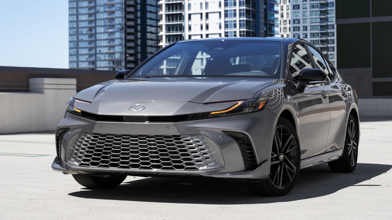 Вид спереди серебристой Toyota Camry 2026 года выпуска, припаркованной в гараже.