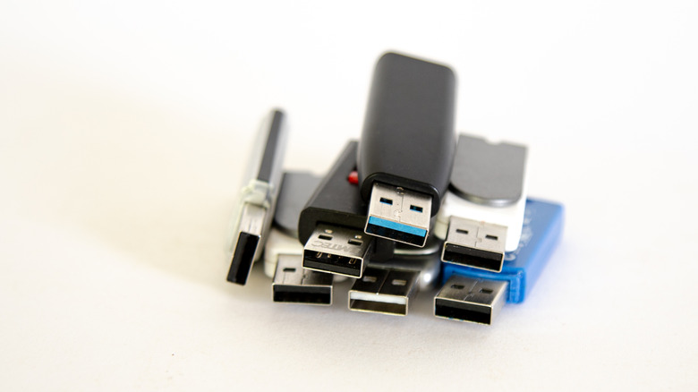 Коллекция из нескольких USB-накопителей разного цвета, сложенных друг на друга.