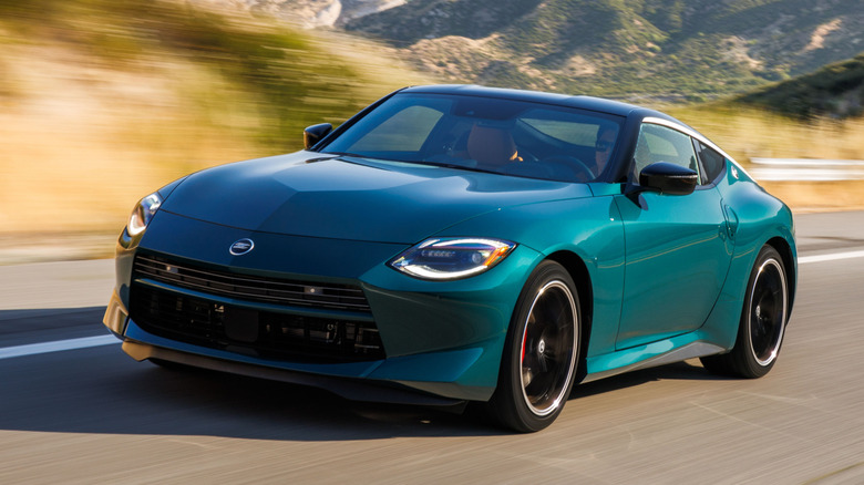 Nissan Z Performance 2027 года в горах, вид спереди 3/4, зеленый кузов