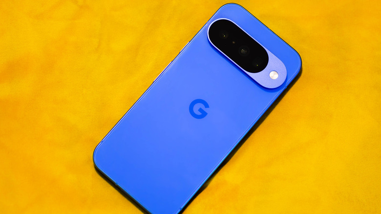 Синий Google Pixel 10 на желтой поверхности