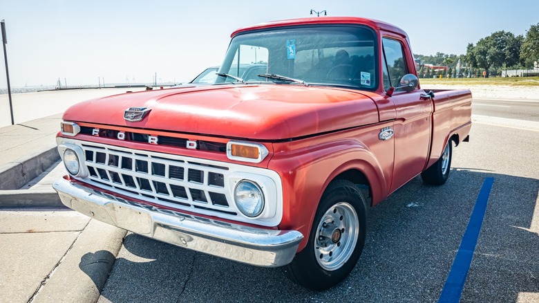 Красный пикап Ford 1965 года выпуска с рядным шестицилиндровым двигателем объемом 300 кубических дюймов.