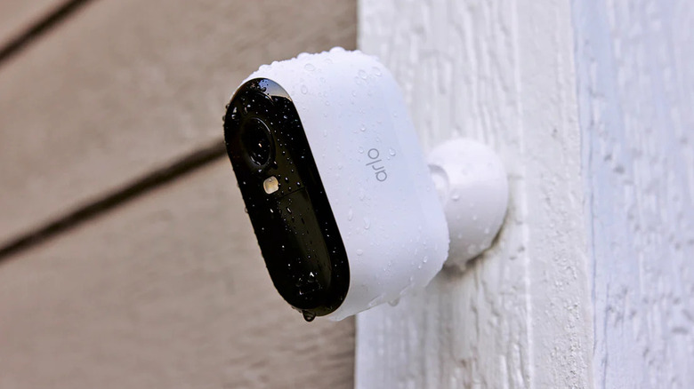 Камера видеонаблюдения Arlo, установленная на открытом воздухе, с каплями воды на ней.