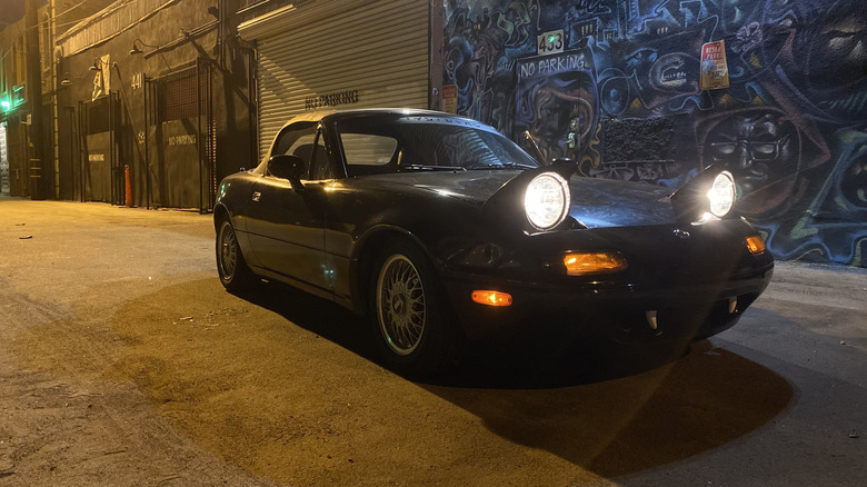 Mazda Miata 1993 года с включенными фарами ночью