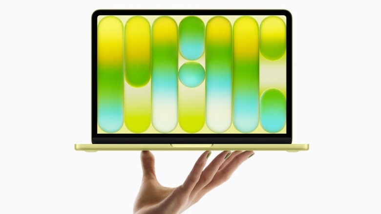 Рука поднимает MacBook Neo