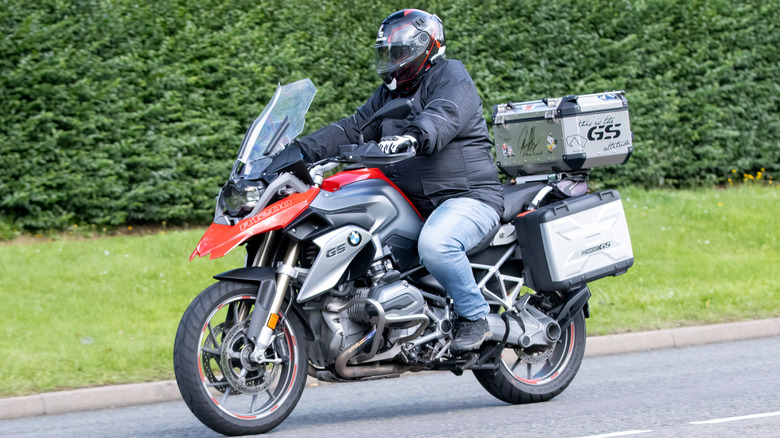 Мужчина едет по дороге на BMW R1200 GS.