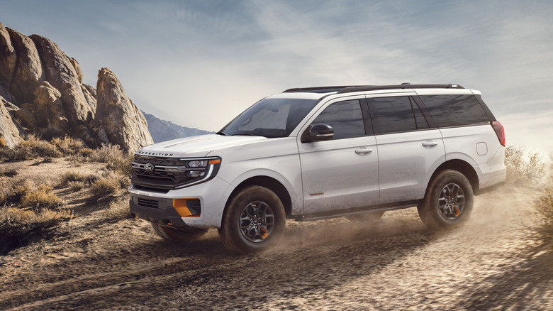 Вид сбоку белого Ford Expedition Tremor на пустынной тропе.