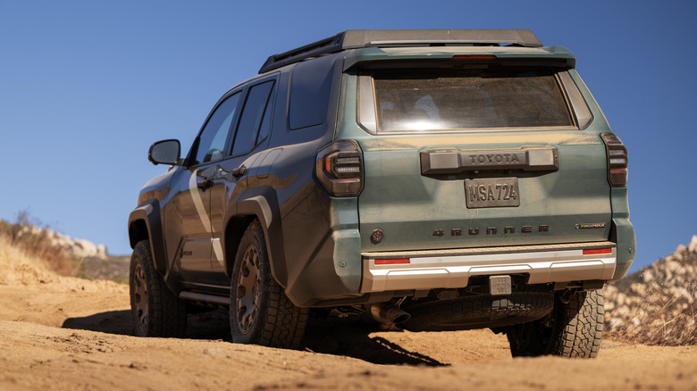 Вид сзади на зеленую Toyota 4Runner на бездорожье.