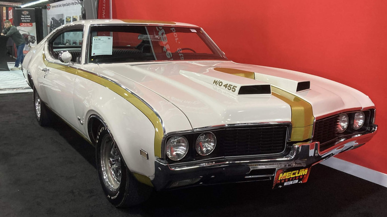 1969 Hurst/Oldsmobile 4-4-2 H/O 455 передний правый 3/4 на красном фоне, белый снаружи с золотыми деталями