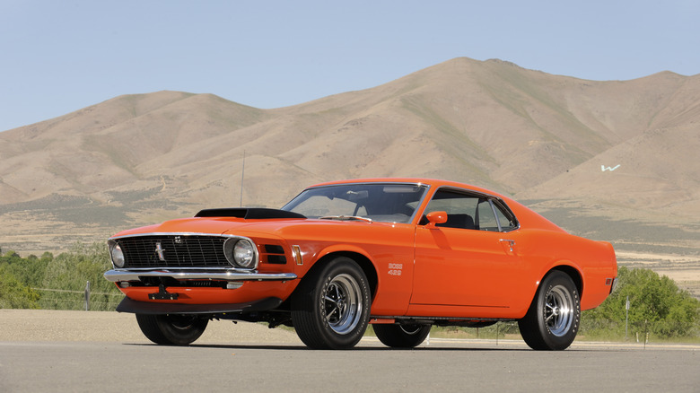 Ford Mustang Boss 429 1969 года на фоне пустыни, вид в 3/4 спереди слева, оранжевый кузов
