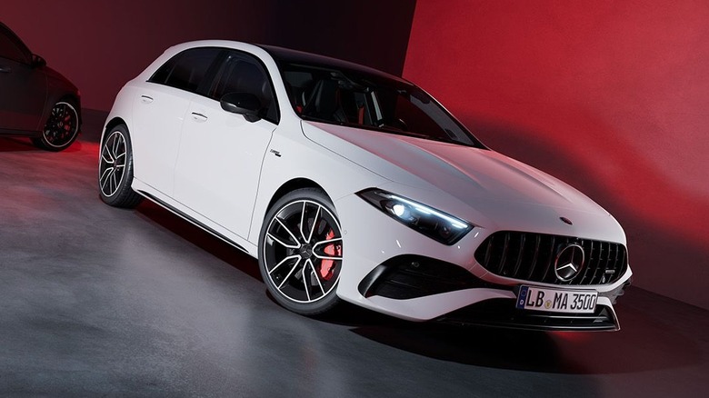 Mercedes-Benz A45 AMG 2026 года на красном фоне, вид спереди справа в 3/4