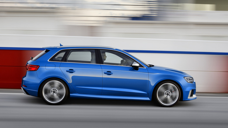Audi RS 3 2016 года движется на скорости по трассе, вид справа