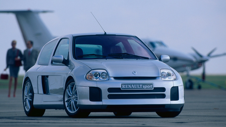 Renault Clio V6 RS Phase I с самолетом на заднем плане, вид спереди справа в 3/4