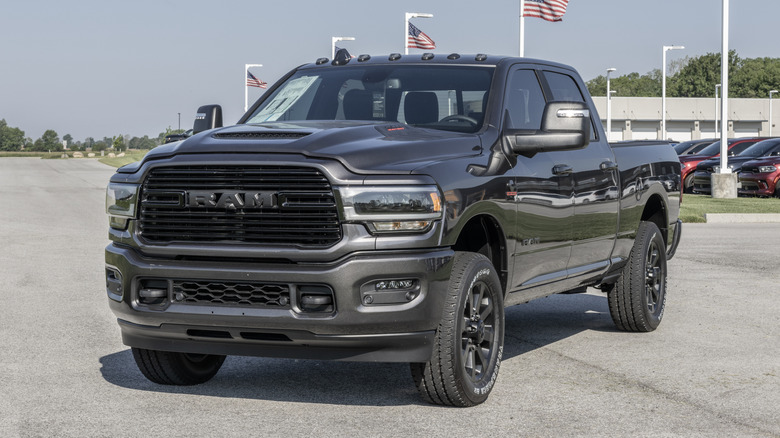 Вид спереди на 3/4 серого пикапа Ram 2500, припаркованного перед автосалоном.