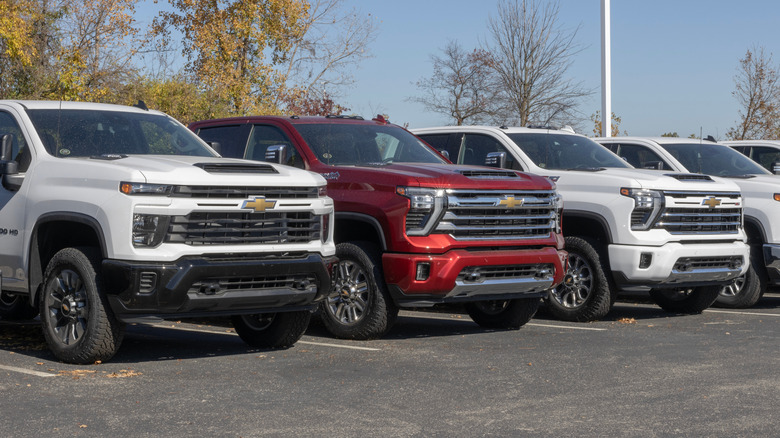Пикапы Chevy Silverado 2500, вид спереди, выстроившиеся в очередь на дилерской стоянке.
