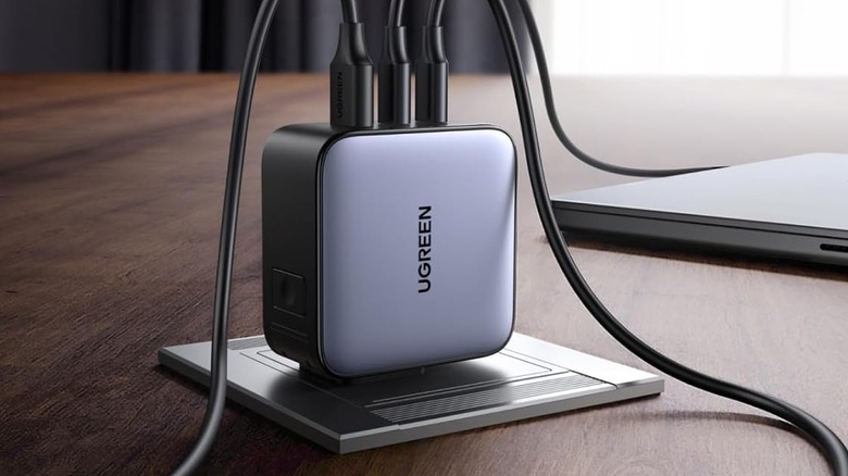 Дорожное зарядное устройство UGREEN на столе с кабелями