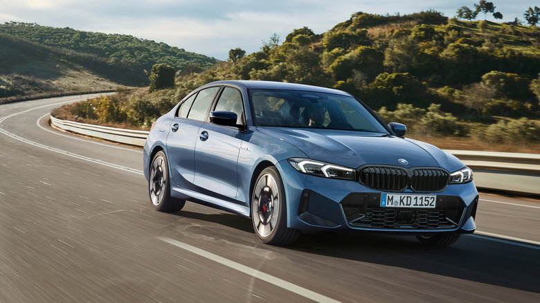Синий BMW 330i едет по горной дороге