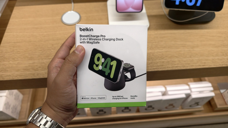 Человек, держащий в руках док-станцию ​​для беспроводной зарядки Belkin