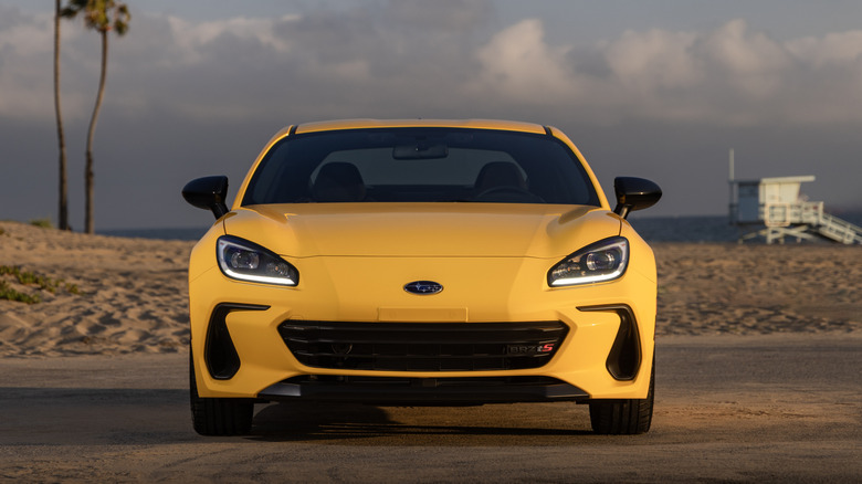 Subaru BRZ 2026 года выпуска ярко-жёлтого цвета, припаркованный возле пляжа.