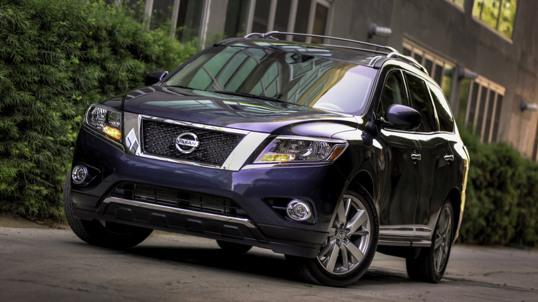 Припаркованный фиолетовый Nissan Pathfinder 2013 года выпуска.