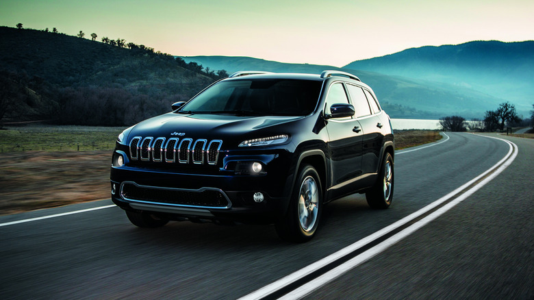 Черный Jeep Cherokee 2014 года выпуска за рулем.