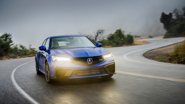 Acura Integra Type S синего цвета едет по дождливой дороге