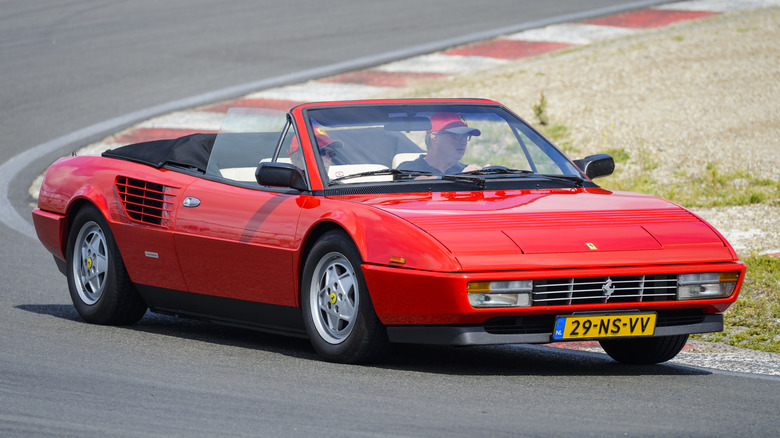 Красный Ferrari Mondial едет по трассе.