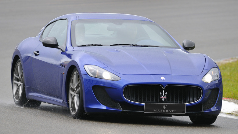 Синий Maserati Gran Turismo едет по трассе.