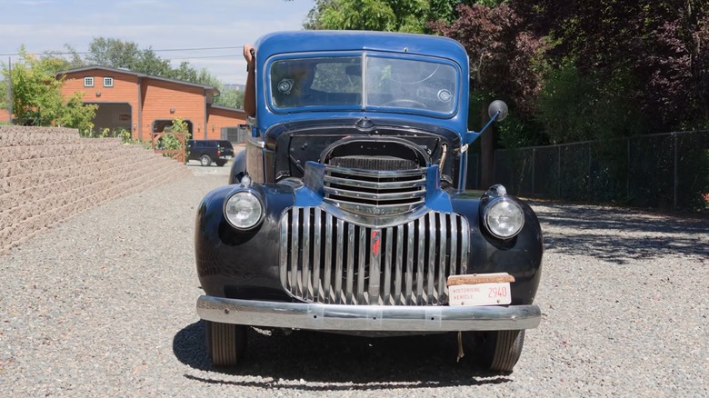 Пикап Chevy 1942 года выпуска едет по дороге.