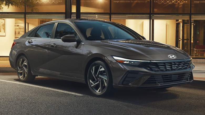 Серый Hyundai Elantra Hybrid 2026 года припаркован перед магазином ночью