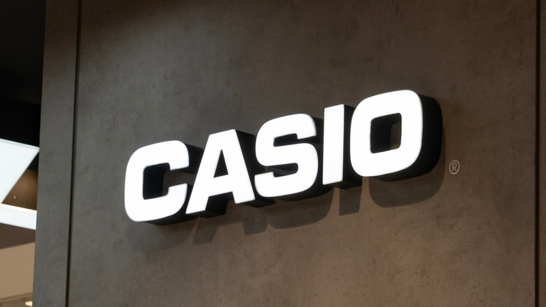 Белый логотип Casio на черной стене.